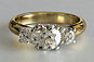 Three Stone Brilliant Lucida Style Crossover Yellow Gold Ring
